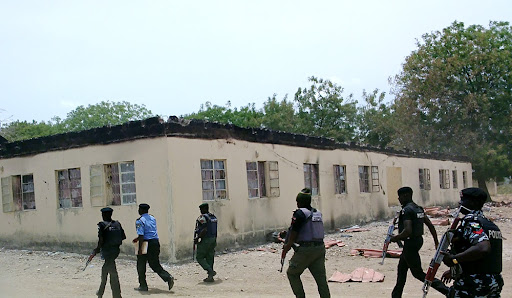 In this photo taken Monday, April, 21. 2014. Security walk past burned government secondary school Chibok, were gunmen abducted more than 200 students in Chibok, Nigeria. (AP Photo/ Haruna Umar)