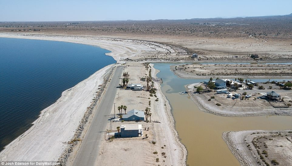 The Salton Sea is known as the 'accidental lake' because it was created by accident. At the beginning of the 19th century, government officials and land developers discovered that the fine-grained fertile soil in the area and hot climate would produce bountiful farmland if water could be irrigated to the region from the Colorado River. Pictured above is an aerial view that shows vacant plots of land in Desert Shores community