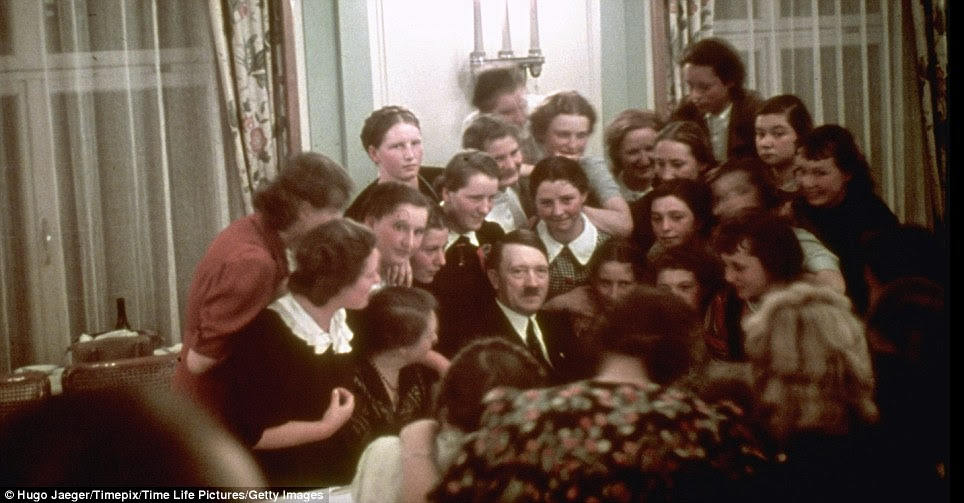 Centre of attention: A group of Austrian schoolgirls crowd around to chat to Hitler at an unidentified social event