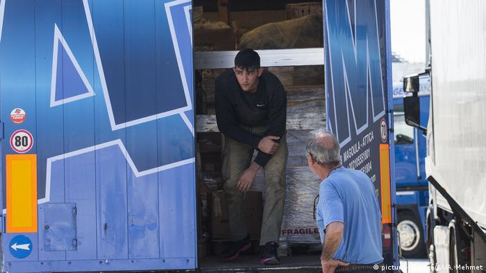 Ein Angehöriger der griechischen Küstenwache entdeckt in Patras einen Flüchtling in einem Lastwagen (Foto: picture-alliance/AA/A. Mehmet)
