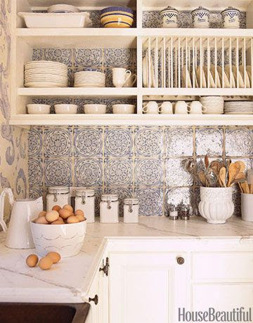 The kitchen backsplash is clad in a romantic blue-and-white French tile form Country Floors. Design: Erin Martin