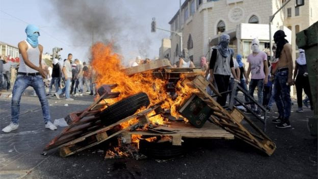 Masked Palestinians surround a bonfire in Shuafat, East Jerusalem (05/10/15)