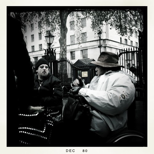 Black and white photo of 2 male wheelchair users conversing