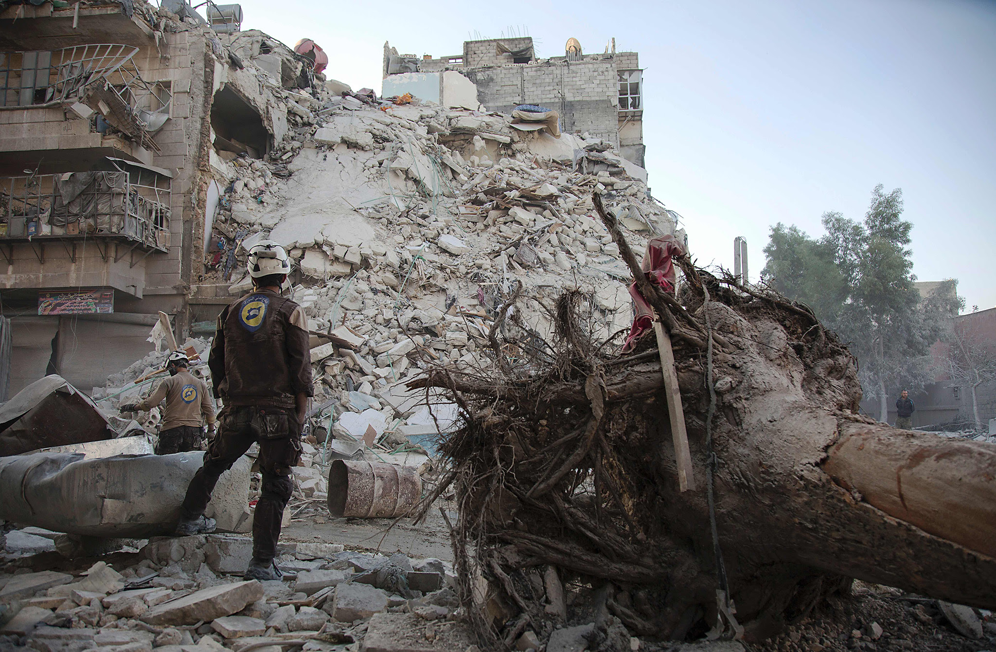 A member of the Syrian Civil Defence, known as the White Helmets, stands amid the rubble of a destroyed building during a rescue operation following reported air strikes in the rebel-held Qatarji neighbourhood of the northern city of Aleppo, on October 17, 2016.  Dozens of civilians were killed as air strikes hammered rebel-held parts of Aleppo early morning, despite Western warnings of potential sanctions against Syria and Russia over attacks on the city. Both Russian and Syrian warplanes are carrying out air strikes over Aleppo in support of a major offensive by regime forces to capture rebel-held parts of the northern city.  / AFP PHOTO / KARAM AL-MASRIKARAM AL-MASRI/AFP/Getty Images