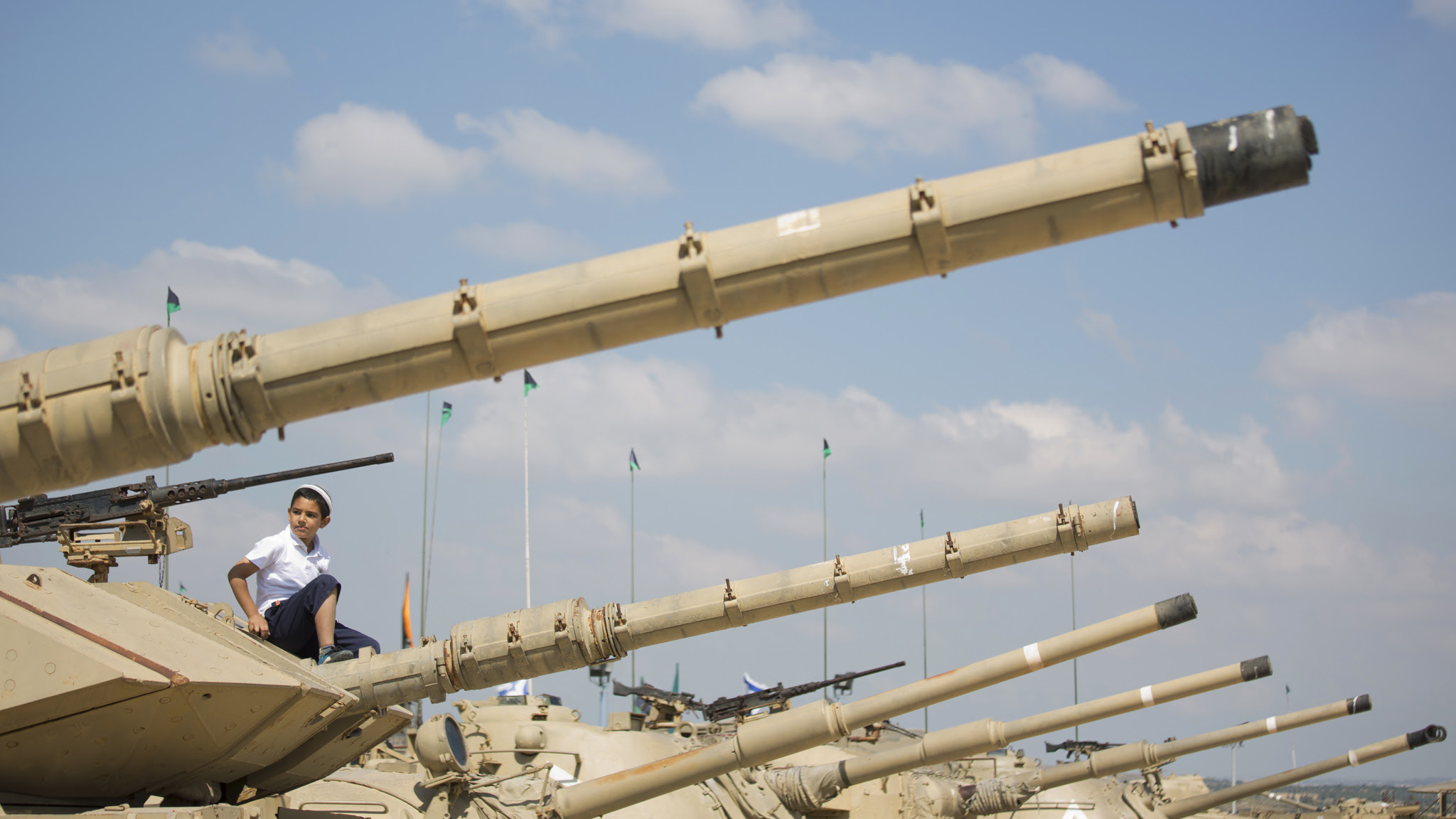 A boy sit on a tank on display at the Armored Corps memorial, before a ceremony marking the annual Memorial Day for soldiers and civilians killed in more than a century of conflict between Jews and Arabs, in Latrun near Jerusalem, Israel, Wednesday, May 11, 2016. Israel came to a standstill on Wednesday as sirens wailed across the country on its annual Memorial Day for fallen soldiers and victims of terrorism. (AP Photo/Ariel Schalit)
