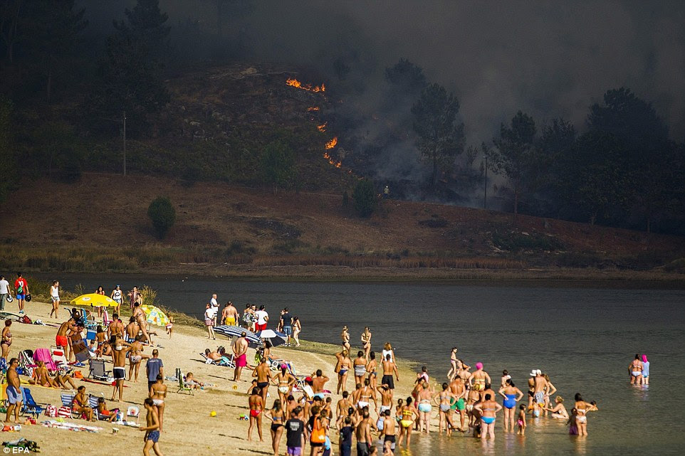 Em Pontevedra, na Galiza, no noroeste da Espanha, perto da fronteira com Portugal, os turistas romper com a natação e banhos de sol para contemplar os incêndios se espalhando por todo o morro