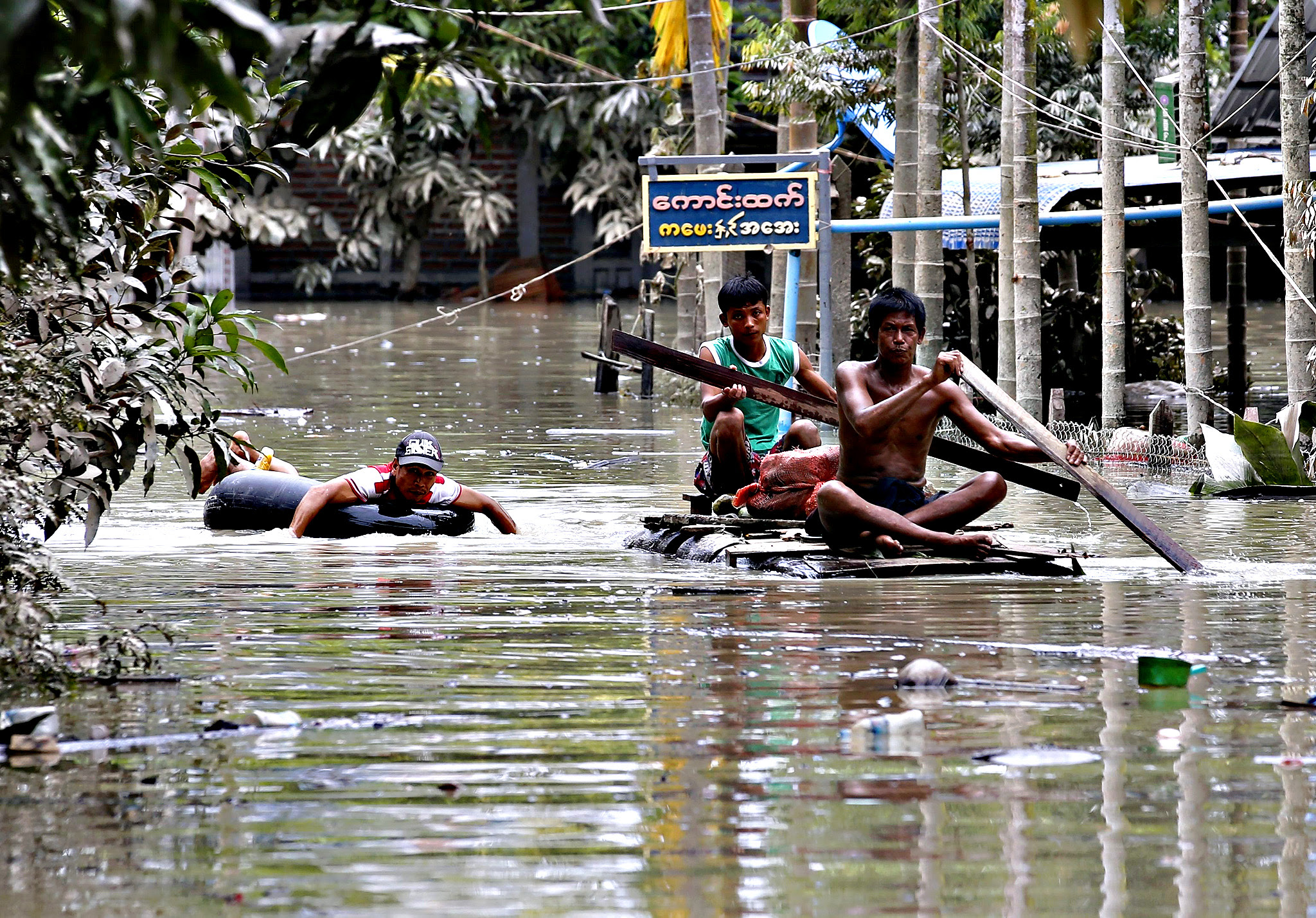Locals use makeshift raft and rubber inner tube as a means of getting through  flooded road in Kale township of Sagaing Region, Myanmar on Monday. Myanmar president  declared four regions (Sagaing, Magway Regions and Rakhine, Chin States) as disaster zones on 31 July 2015. Heavy monsoon rains caused floods around Myanmar with dozens deaths being reported as thousands are fleeing their homes in several regions across the country. In Myanmar monsoon starts at the beginning of June and ends in September.