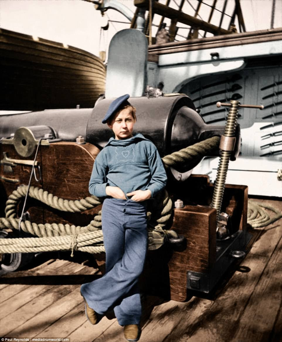 A boy dressed as a powder monkey on a Union vessel used in the American Civil War. Cutlasses are visible on the wall in the background, in 1911. The term 'powder monkey' referred to boys on sailing warships who carried powder to the guns