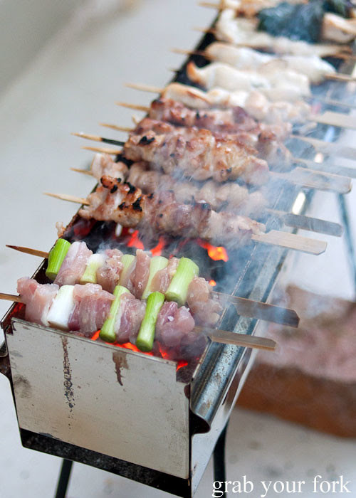 yakitori chicken thigh fillet with leek skewers on an arrosticini charcoal grill at a stomachs eleven japanese dinner