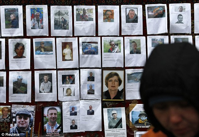 Photos of those killed in recent violence are seen at a make-shift memorial. Ukraine's parliament voted on Tuesday to send fugitive President Viktor Yanukovich to be tried by the International Criminal Court for 'serious crimes' committed during violent anti-government protests in which scores were killed