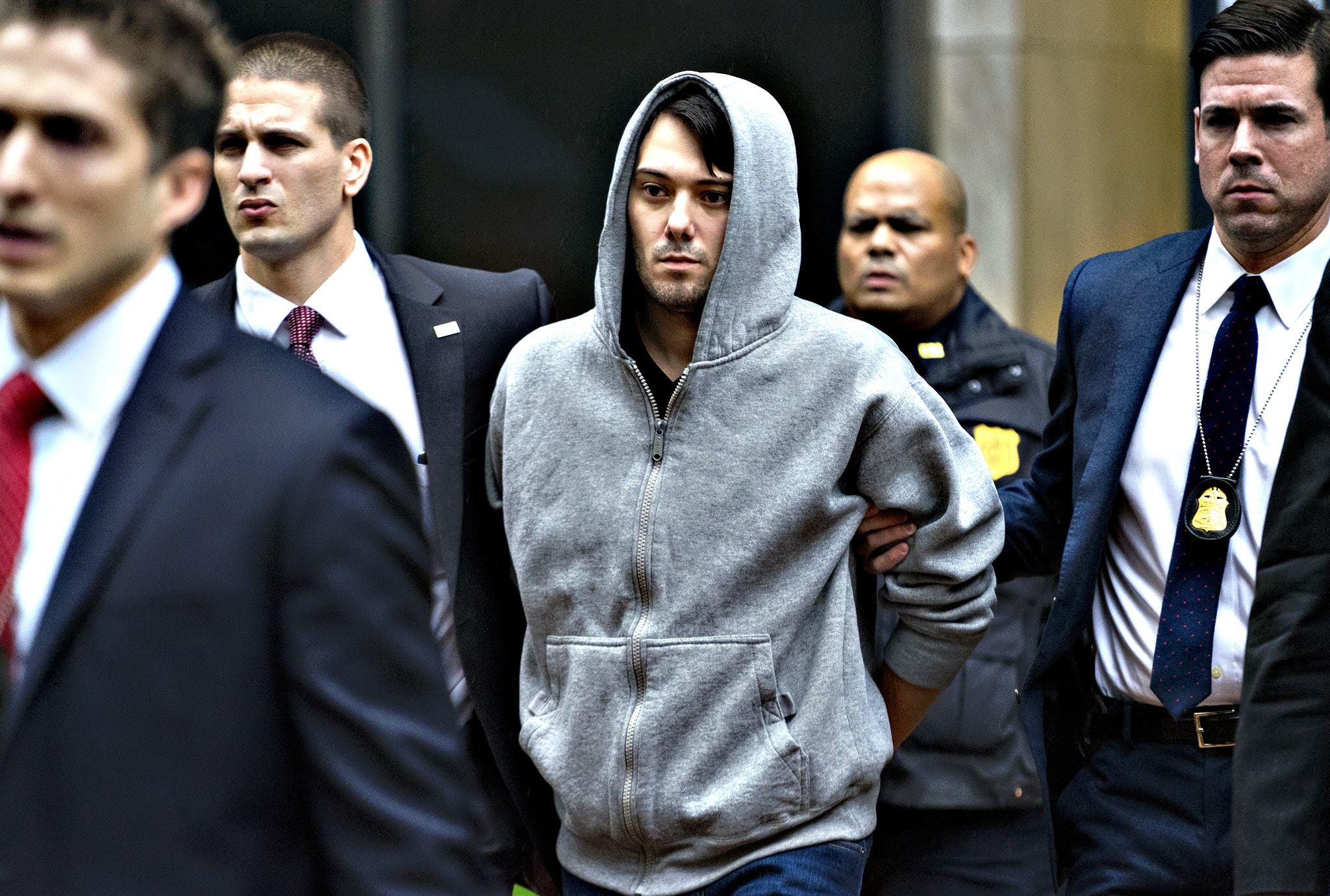 Martin Shkreli, the former hedge fund manager under fire for buying a pharmaceutical company and ratcheting up the price of a life-saving drug, is escorted by law enforcement agents in New York Thursday, Dec. 17, 2015, after being taken into custody following a securities probe. A seven-count indictment unsealed in Brooklyn federal court Thursday charged Shkreli with conspiracy to commit securities fraud, conspiracy to commit wire fraud and securities fraud.