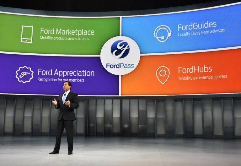 Ford CEO Mark Fields standing in front of large curved screen showing images of Ford Pass