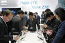 Visitors look at devices at ZTE booth at the Mobile World Congress in Barcelona