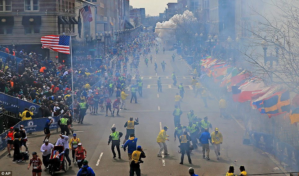 Exact Moment: People react as an explosion goes off near the finish at the Boston Marathon finish line on Monday, sending authorities out on the course to carry off the injured