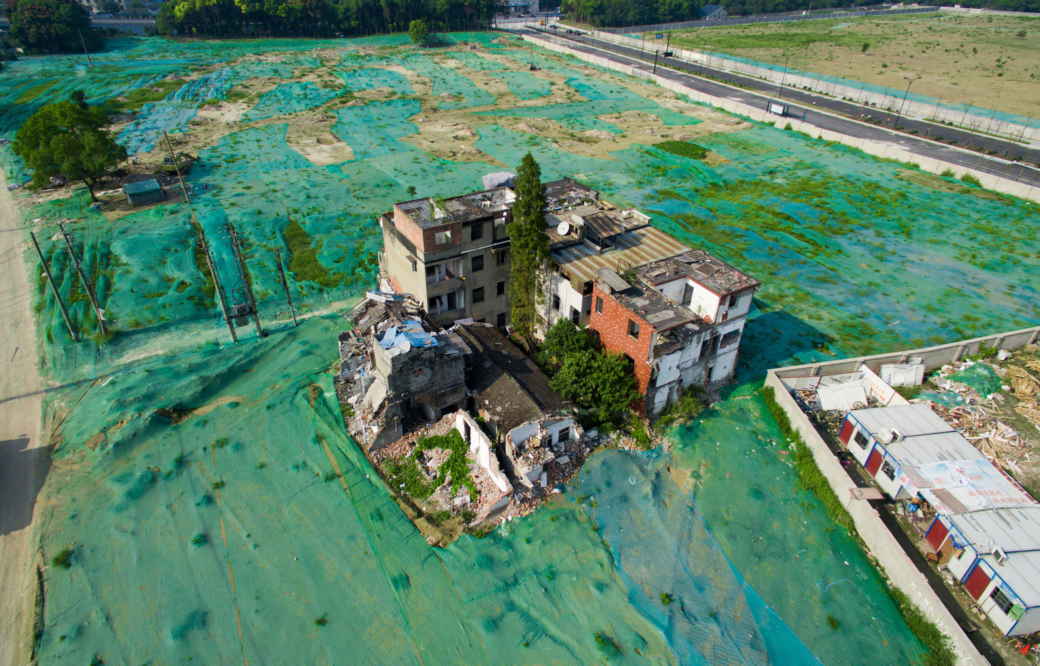 A nail house is seen in the middle of an area covered by a dust screen in Hangzhou, Zhejiang province, China