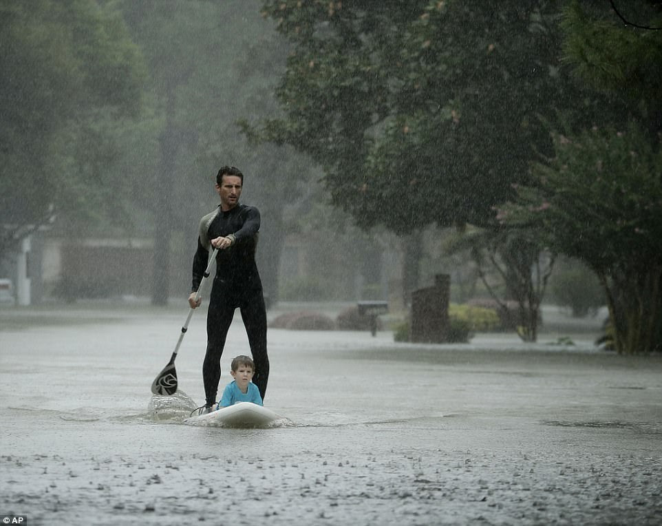 Alexandre Jorge evacuates Ethan Colman from his home in Houston on Monday