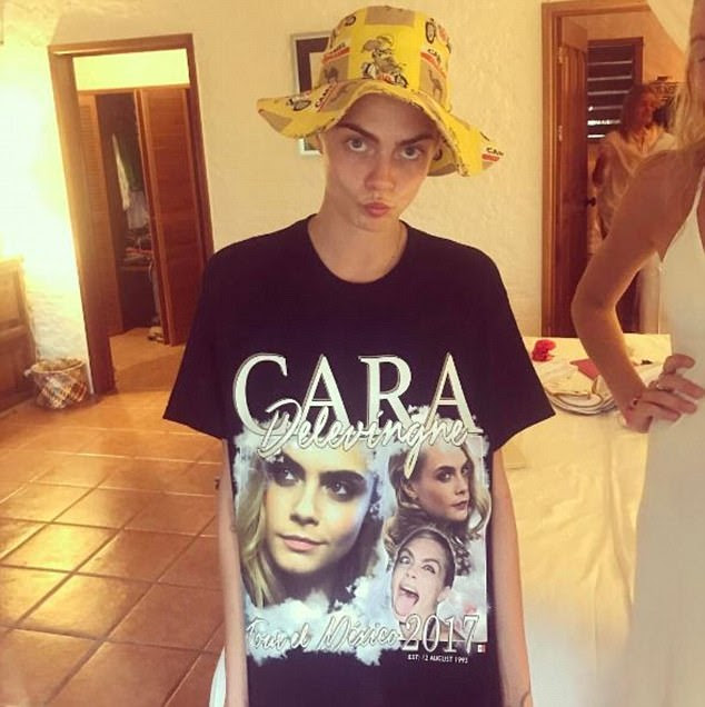 Modelo do momento: Cara brilhou uma calda quando ela posava em uma camiseta com o rosto e um chapéu de balde estranho