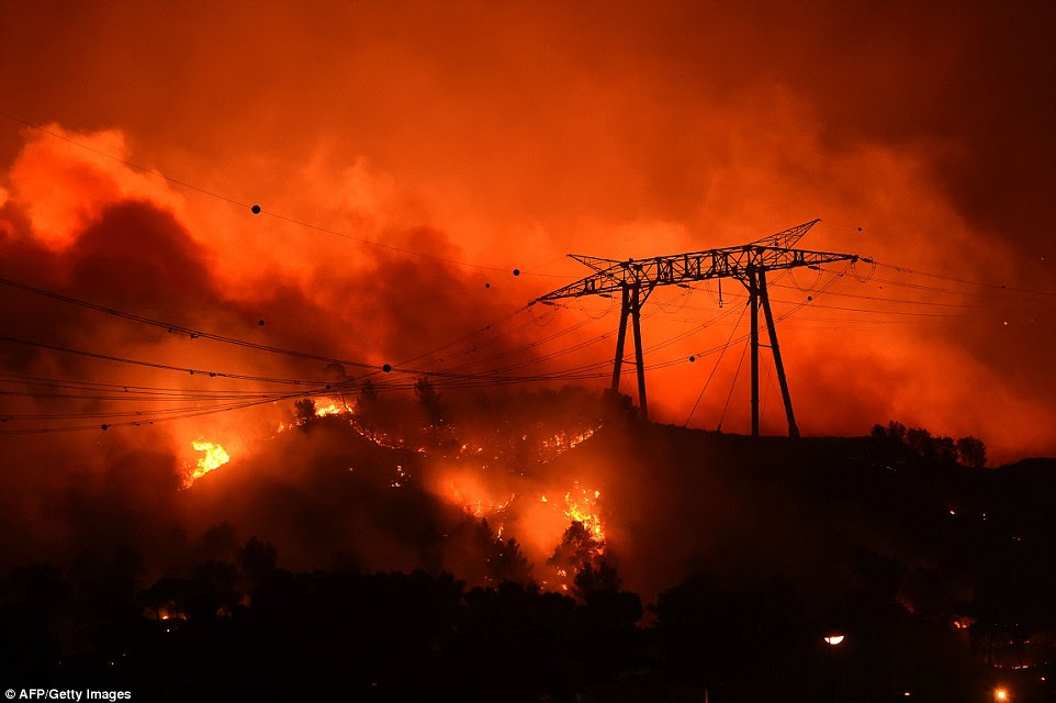 Os incêndios ardiam através encostas em Les Pennes-Mirabeau, perto de Marselha, na noite passada, mesmo colocando em risco linhas de energia