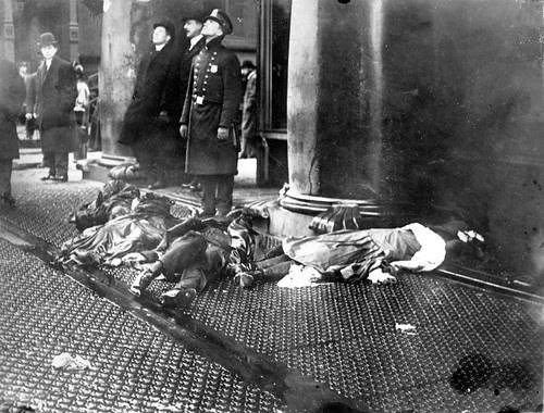 police-officer-with-bodies-of-Triangle-fire-victims-at-feet-looking-up-at-workers-poised-to-jump-from-the-upper-floors-of-the-burning-Asch-Building.jpg