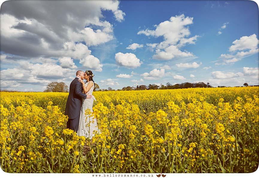 Bride and groom in field of yellow rapeseed oil field - www.helloromance.co.uk