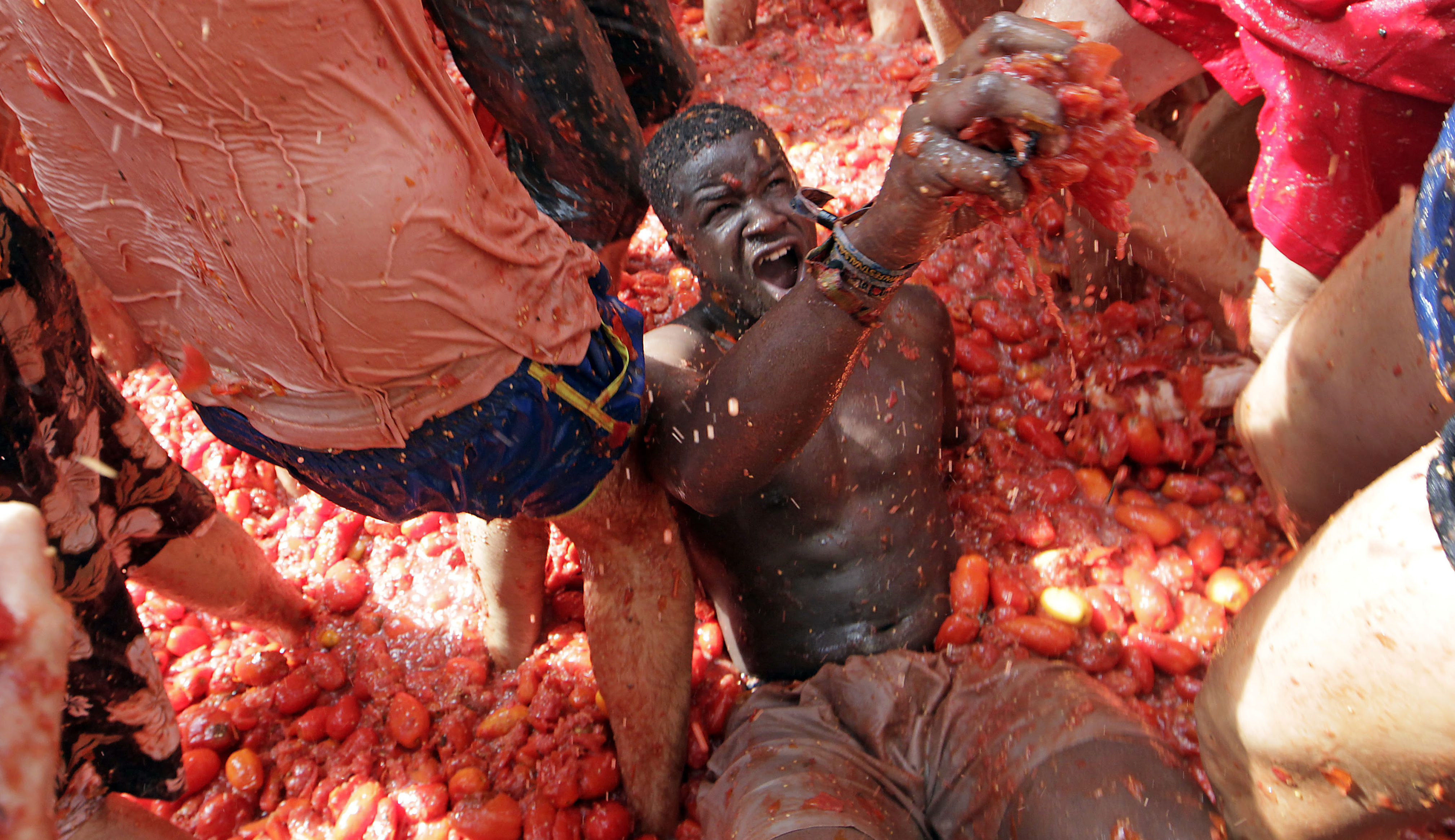 Crowds of people throw tomatoes at each other, during the annual "Tomatina", tomato fight fiesta, in the village of Bunol, 50 kilometers outside Valencia, Spain