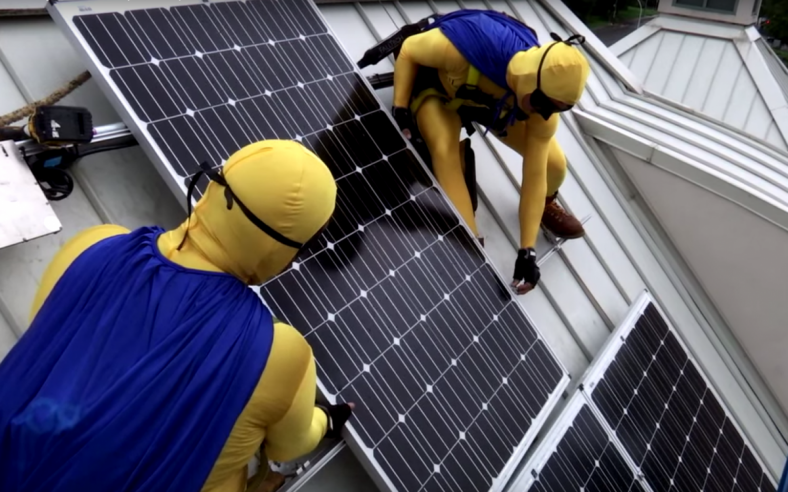 Solar installers dressed up as superheroes to complete the installation on the KidsQuest Children’s Museum in Washington as part of the Solarize Bellevue campaign. Photo by Allison DeAngelis. Solar installers dressed up as superheroes to complete the installation on the KidsQuest Children’s Museum in Washington as part of the Solarize Bellevue campaign. Photo by Allison DeAngelis.