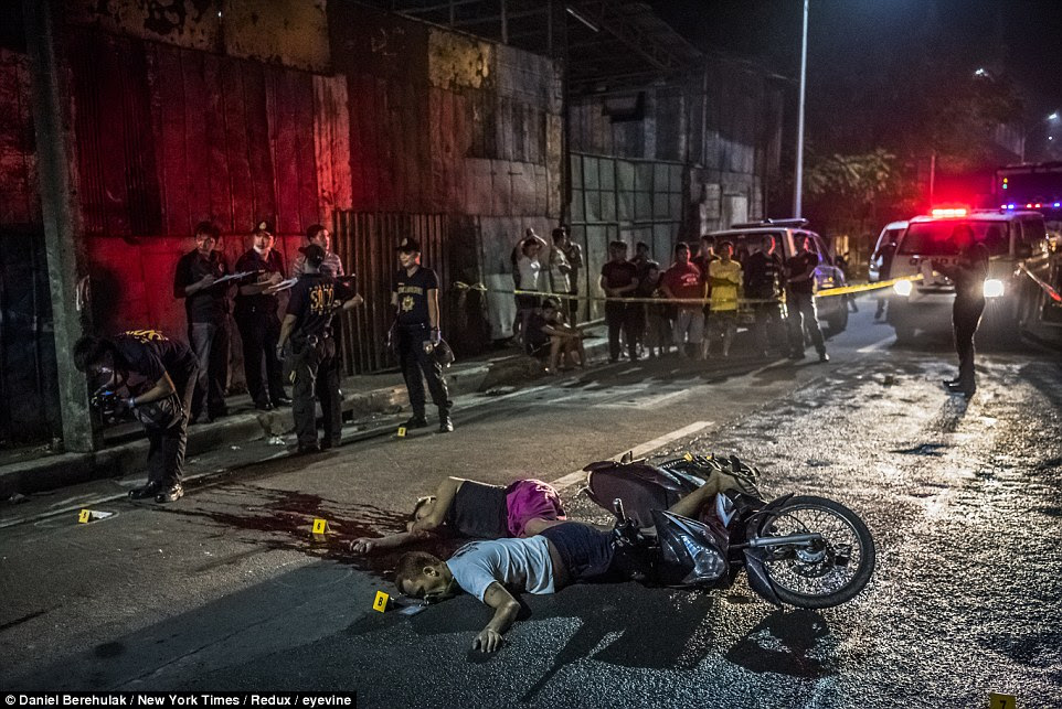 The bodies of Frederick Mafe, 48, and Arjay Lumbago, 23, who were riding together on a motorbike when they were killed by a pair on another motorbike, in Quezon City, Philippines