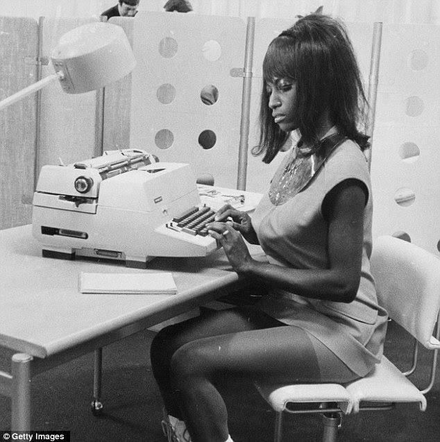 In the spotlight: A woman wears a flesh-exposing ensemble as she sets to work at a typewriter 