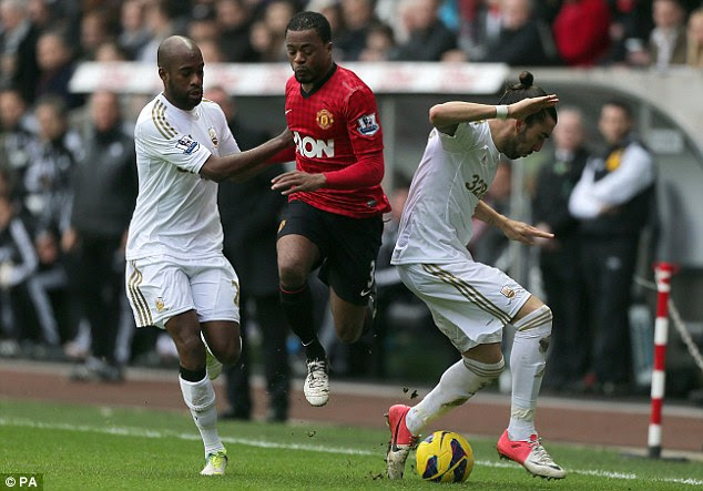 Evasive action: Patrcie Evra (centre) is challenged by two Swansea defenders