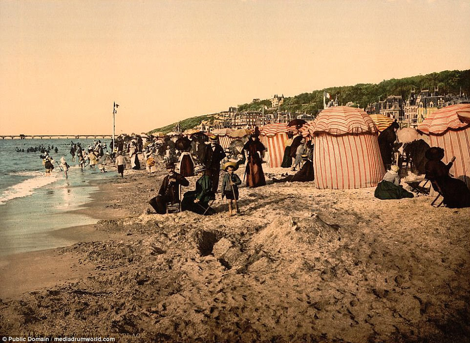 La belle vie: Images also capture families enjoying the beach at high tide in the seaside resort of Trouville in Normandy
