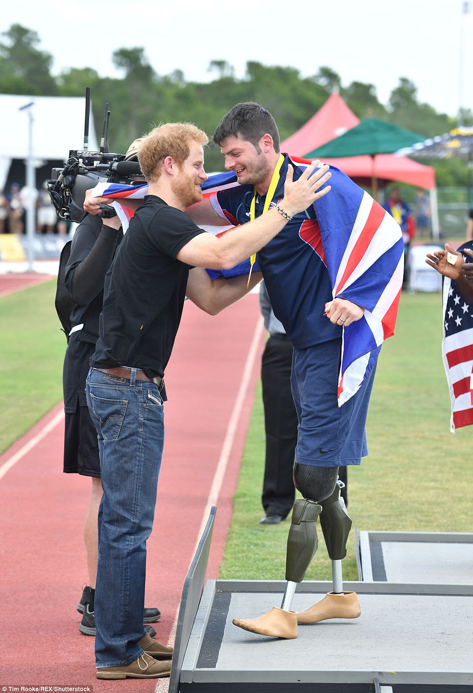 Harry looked pleased as punch as he presented the gold medal to Brit David Henson a retired army captain who lost both of his legs when he stood on an IED