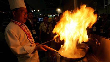 A Chinese chef demonstrates his cooking skills to visitors during the 12th Asian International Exhibition of Food and Drink, Hotel, Restaurant & Foodservice Equipment Supplies & Services (HOFEX) at the Hong Kong Exhibition Center in 2007.