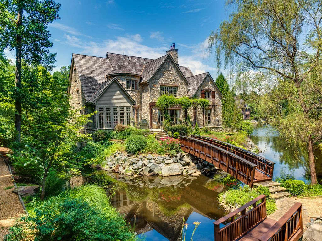 Country Exterior of Home with Pathway, Wood bridge, Trellis, Pond, River rock exterior facade, Gravel driveway