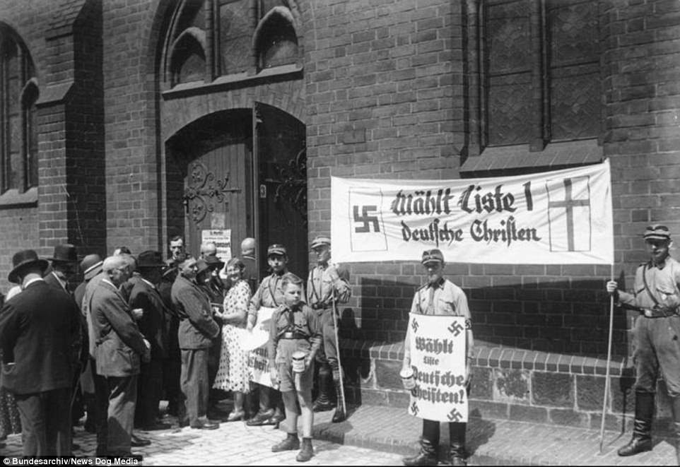 These members of the SA - the original internal
                    police force of the Nazi Party - until they were
                    brutally replaced by Heinrich Himmler's SS - along
                    with a boy in the Hitler Youth are holding a
                    demonstration outside a church in Berlin on July 23,
                    1933, a week after he abolished all opposition
                    political parties having earlier scrapped Trades
                    Unions 