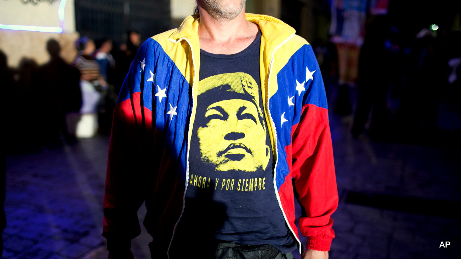 A pro-government supporter wears a T-Shirt with image of Venezuela's late President Hugo Chavez, as he waits for results during congressional elections in Caracas, Venezuela, Sunday, Dec. 6, 2015. 