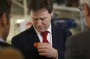 Britain's Deputy Prime Minister Nick Clegg removes a sticker supporting Liberal Democrats Eastleigh by-election candidate Mike Thornton, during a visit to the Aston Martin production facility in Gaydon