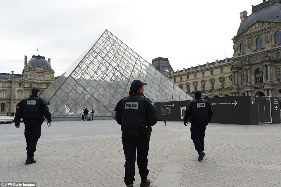 Police patrol  in front of the Louvre Pyramid at the Louvre museum in Paris as the country was placed in a nationwide state of emergency