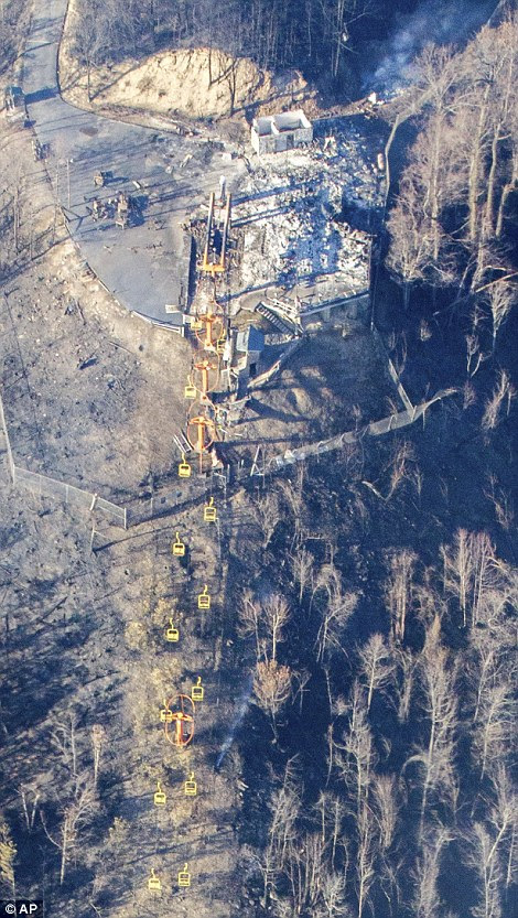 The mountain cable cars hover over the burned out mountainside while smoke still lingers above the smoldering homes near Gatlinburg
