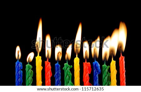 Burning candles on black background - stock photo