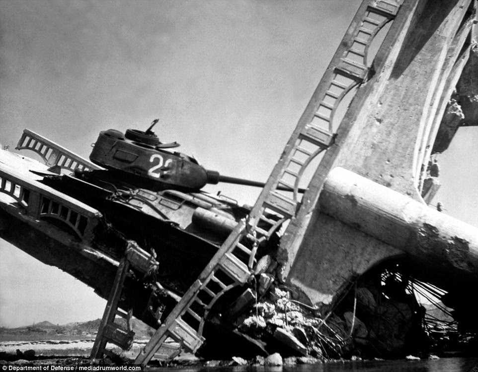 The wreckage of a bridge and North Korean Communist tank south of Suwon, Korea. The tank was caught on a bridge and put out of action by the US Air Force