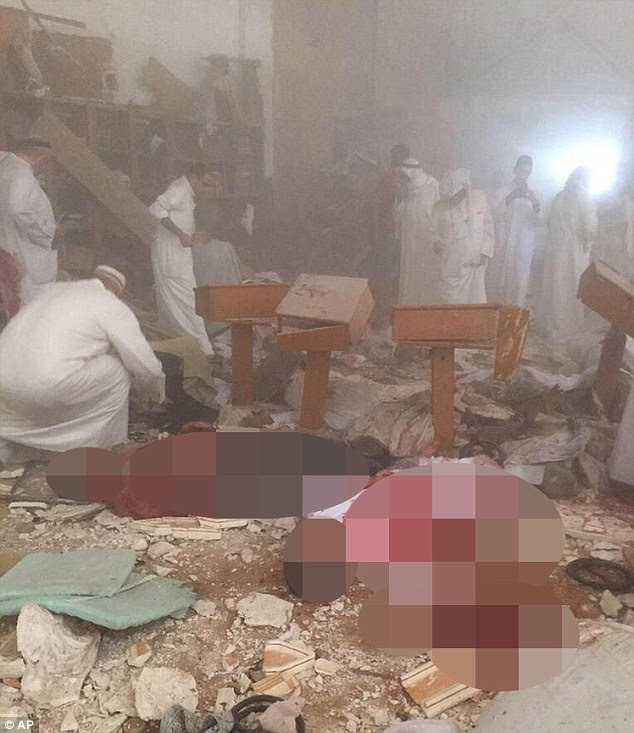 Aftermath: Mourners climb through the rubble and dust in the search for bodies after a suicide bomber killed 25 in Kuwait