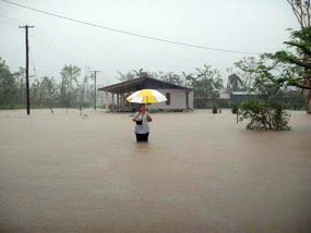 A woman holding an umbrella stands in floodwaters as rain falls in Cardwell. March 8, 2011. A woman holding an umbrella stands in floodwaters as rain falls in Cardwell. March 8, 2011.