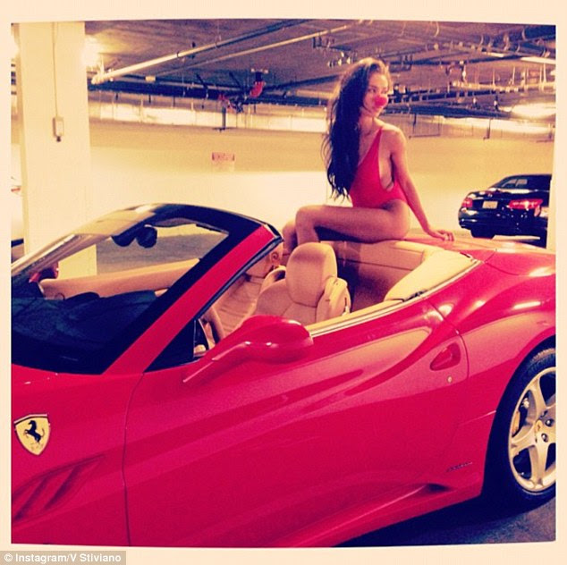 Clowning around: Stiviano posed last April in a red bikini and a clown nose sitting in a Ferrari that Sterling allegedly bought for her with family money