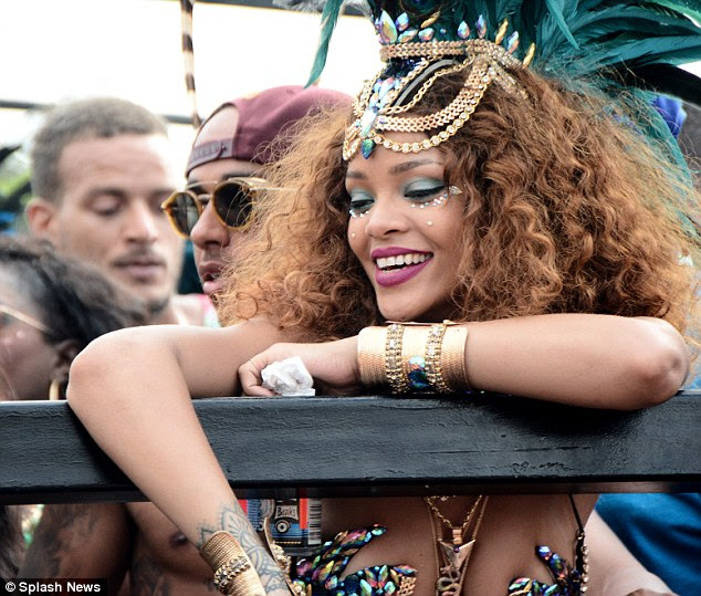 Rihanna holds a drink as she cosies up to the Formula One star, who is currently on a mid-season break
