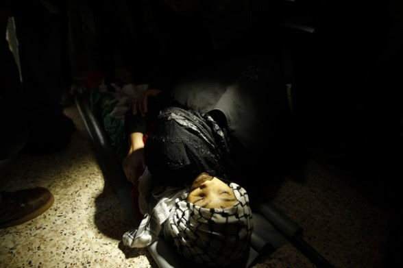 A Palestinian woman mourns over the body of 13-year-old boy Mahmoud Abu Samrah during his funeral in Gaza City