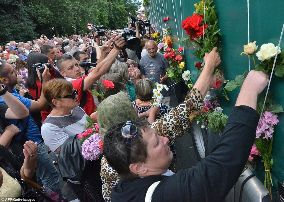 Bosnians, citizens of Sarajevo, put flowers on a truck carrying the remains of victims of the Srebrenica 1995 massacre, on July 9, 2014 in Srebrenica. Bosnia will bury 175 victims of the Srebrenica massacre on July 11, on the 19th anniversary of Europe's worst atrocity since World War II. "The remains of 175 massacre victims have been prepared for a joint funeral at the Potocari memorial centre" near the eastern town, a spokeswoman for Bosnia's Institute for Missing People told AFP on July 4.  Around 8,000 men and boys died in the Srebrenica massacre which followed the town's seizure by Bosnia Serb forces on July 11, 1995. It was labelled a genocide by two international courts. So far, the remains of 6,066 people have had their remains exhumed from mass graves in the Srebrenica region for reburial in the Potocari cemetery. The massacre took place just a few months before the end of Bosnia's 1992-1995 war, which claimed some 100,000 lives in total. AFP PHOTO / ELVIS BARUKCICELVIS BARUKC