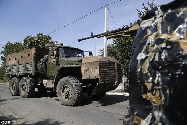 Pro-Russian rebels drive an armored truck through the city of Donetsk, in eastern Ukraine