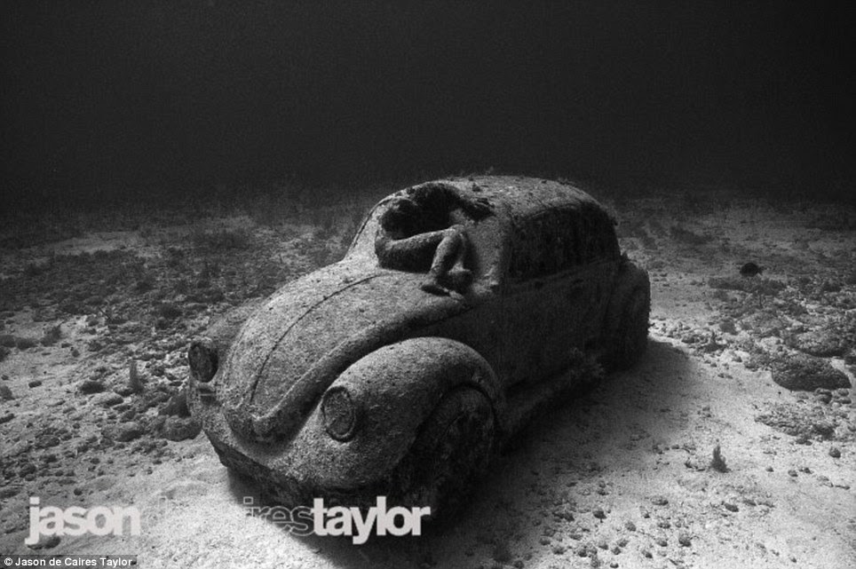 Eco-friendly drive: A Volkswagen Beetle is seen on the ocean's floor with the body of a human curled on its windshield in what too will provide an eco-friendly home to the otherwise barren floor