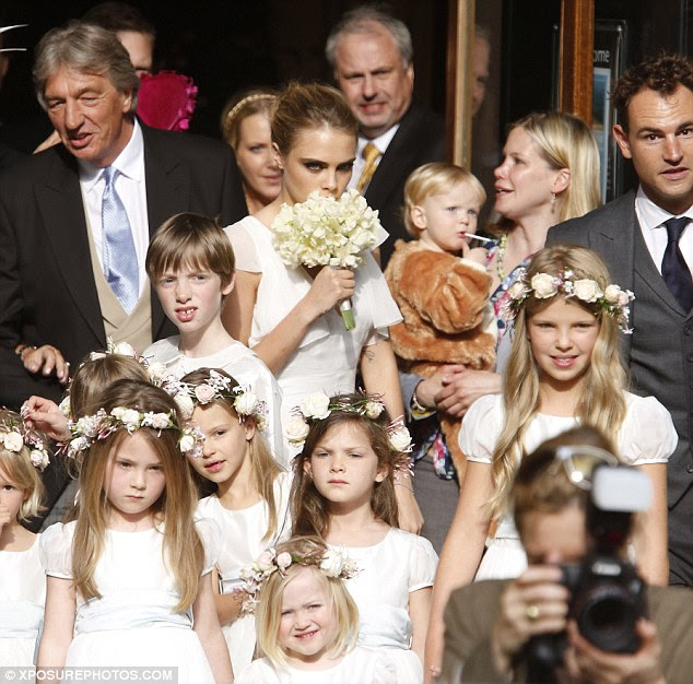 Feeling shy: Cara, who must be used to having her photo taken, hid behind her bunch of flowers