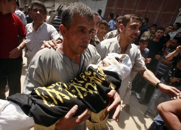 A Palestinian man carries the body of two-year-old boy Islam Qreqa during a funeral in Gaza City